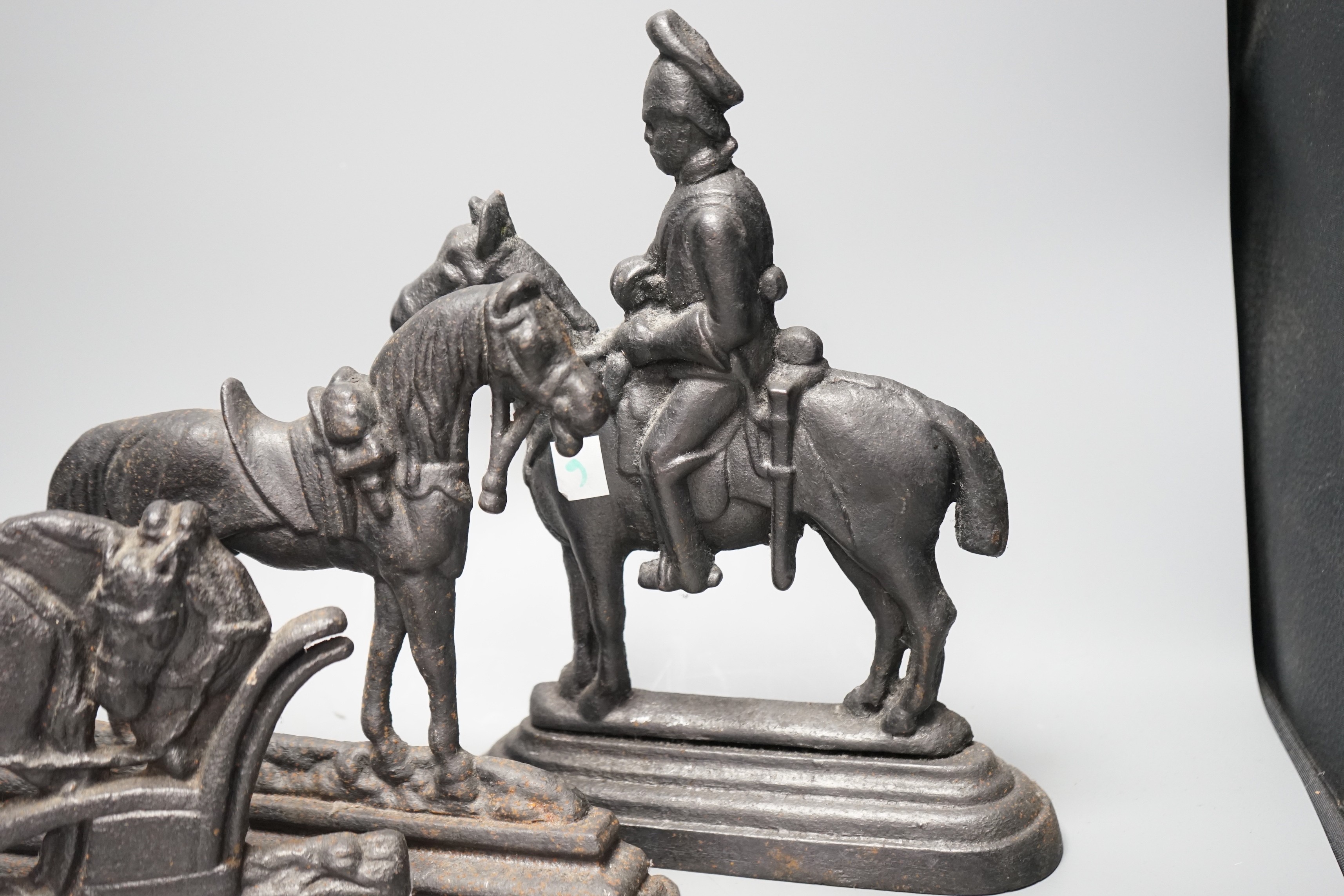 Four assorted cast iron horse door stops, tallest guardsman on horse back 28cms high